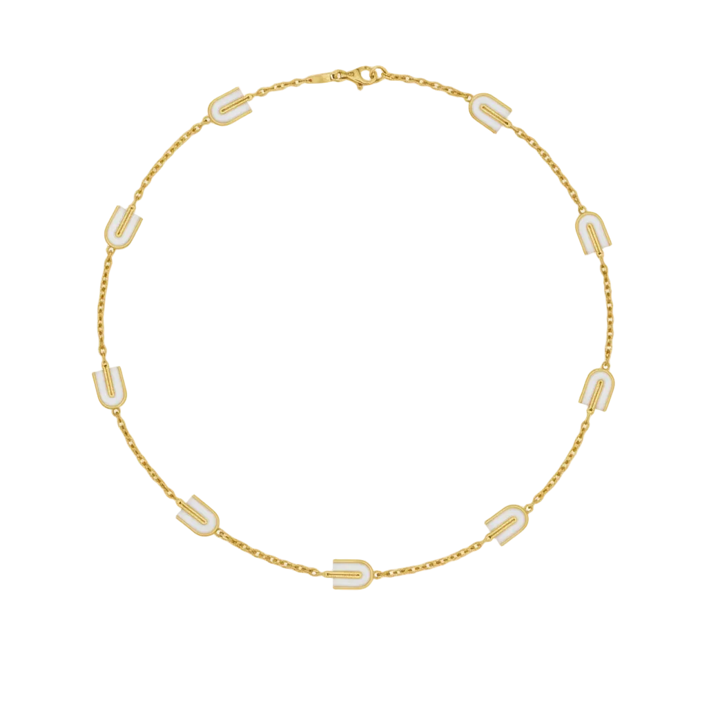 Gold necklace with white geometric pendants on a white background